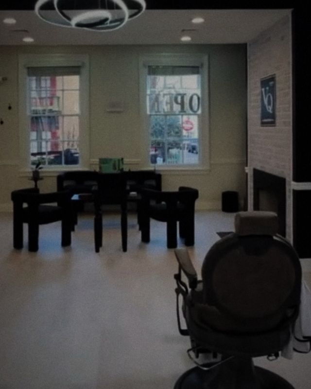 A barber chair facing the front windows and waiting area