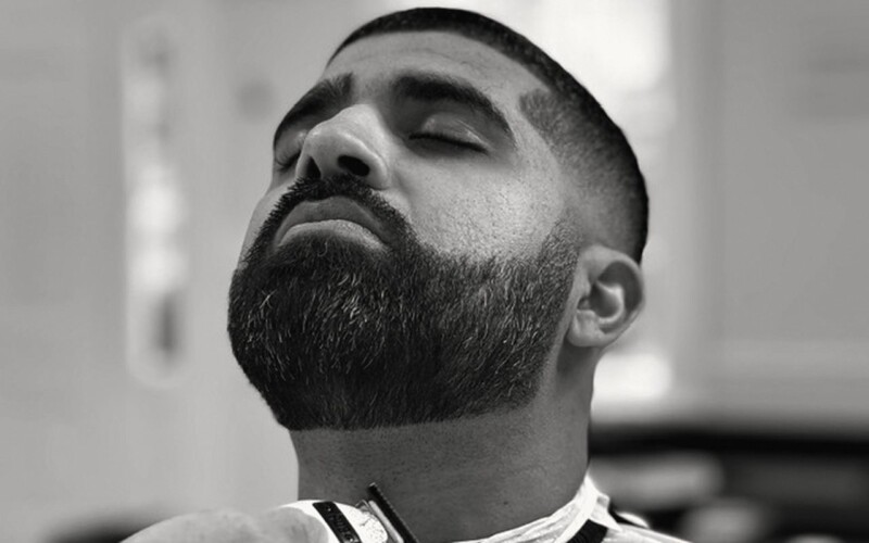 Beard line-up with a trimmer, head tilted back