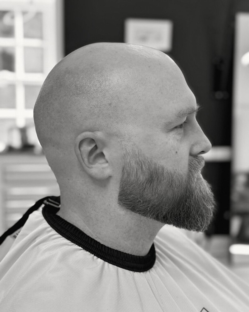Clean head shave with a shaped beard