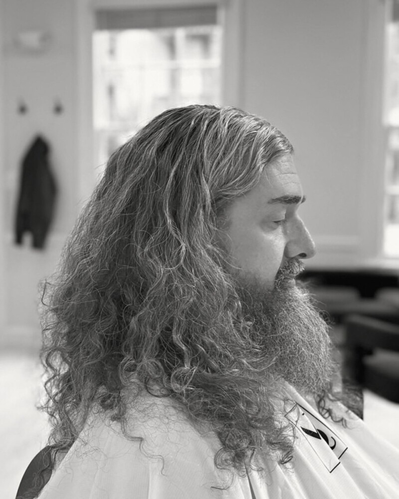 Long wavy hair and a full beard, kept in shape