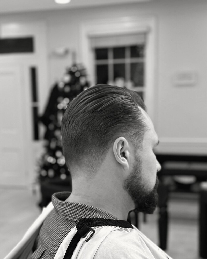 Slicked-back cut with tapered sides and a beard