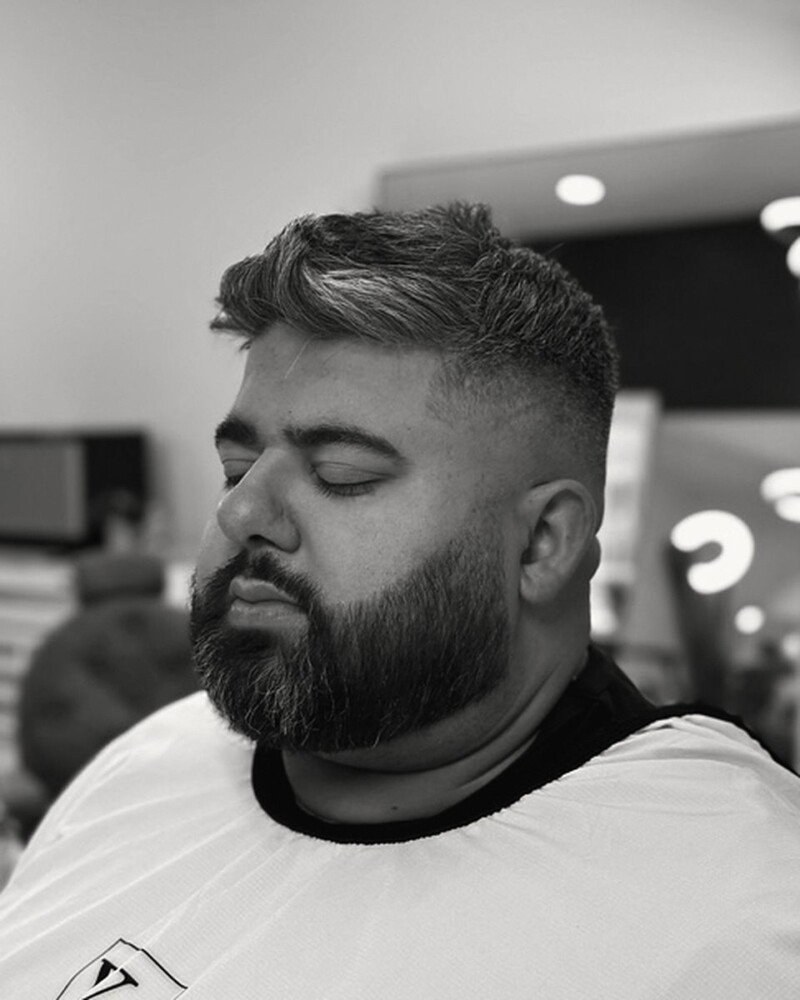 Fade with a textured top and full beard, front on