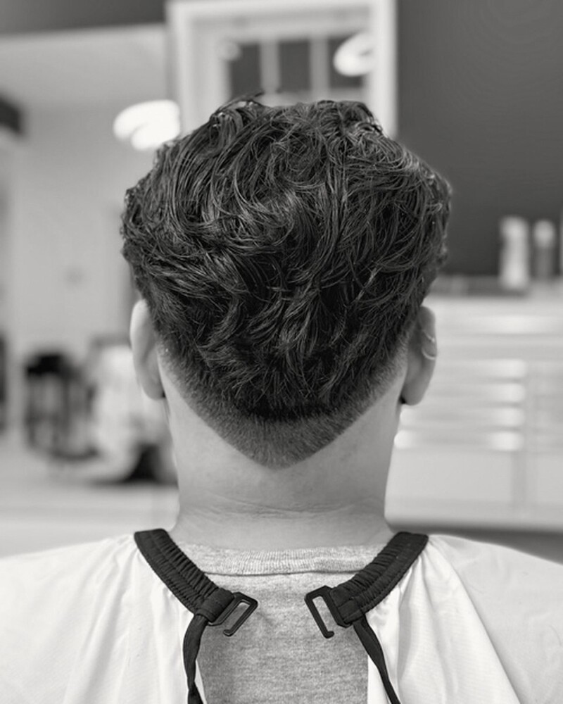 Dark wavy hair shaped at the back